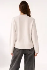 Sweater de viscosa color beige, con cuello polera, corte holgado y pespuntes decorativos en el frente.