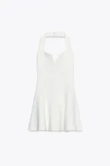 Vestido corto blanco de tejido de punto elástico, con cuello halter, escote corazón y cierre con botones en el cuello.