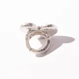 Anillo plateado con forma de corazón con textura irregular.