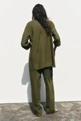 Blazer color verde oliva confeccionada en lino, con cuello solapa, manga tres cuartos con vuelta y cierre cruzado con botones.