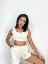 Top corto blanco de algodón, sin mangas y con cuello redondo.