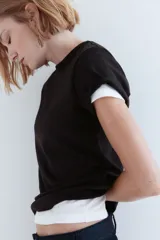 Remera negra de punto de algodón tupido con cuello redondo ribeteado acanalado.