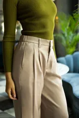 Pantalón palazzo de tiro alto color violeta, de satén. Tiene pretina delantera con pasadores, botón y cierre, pretina trasera elastizada y bolsillos verticales delanteros.