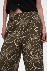 Pantalón capri negro con estampado floral en color crema, de corte ancho y tiro alto.
