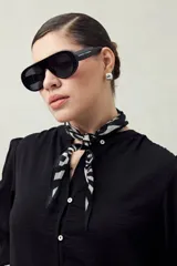 Camisa color marrón claro con cuello mao, mangas 3/4 abullonadas y cierre frontal con botones. Presenta pequeños pliegues en los hombros y detalle calado sutil.