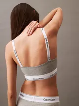Corpiño gris de algodón modal con banda inferior elástica blanca con logo Calvin Klein.