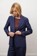 Blazer azul de jean textil, con solapa clásica, un botón frontal y bolsillos laterales.