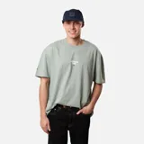 Remera verde de corte holgado con estampado pequeño en el centro del pecho.