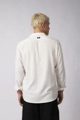 Camisa color crudo de lino con caída liviana y calce relajado, cuello abierto y manga larga. Confeccionada en 70% rayón y 30% lino.