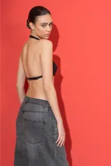 Mini top negro de cuero sintético con tirantes finos y hebilla de ajuste frontal.