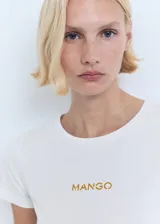 Remera blanca de algodón con cuello redondo y logo 'Mango' estampado en color dorado en el centro del pecho.