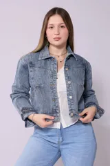 Campera de jean de mujer, color azul claro lavado, con corte cropped y estilo clásico. Presenta cuello camisero, botones metálicos frontales y bolsillos de parche en el pecho.