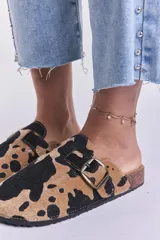Zuecos con estampado de vaca en tonos camel y negro, con hebilla metálica ajustable y plantilla anatómica.