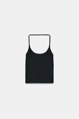 Top corto negro de tejido seamless, con escote redondo pronunciado al frente y espalda descubierta con tiras finas que se unen en la parte superior. Presenta un bajo recto y un área de soporte sutil bajo el busto.