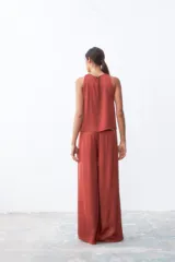 Pantalón palazzo color ladrillo, de tiro alto y corte holgado.