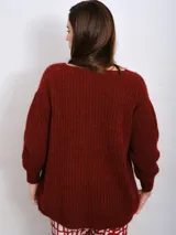 Cardigan marrón de punto grueso con cuello en V, cierre frontal con botones y parche bordado en el pecho.