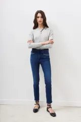 Jean de corte slim, tiro medio, confeccionado en denim azul con lavado localizado y detalles de hot fix en los bolsillos delanteros.