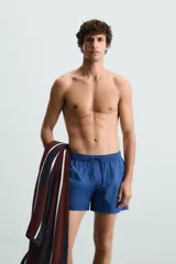 Short de baño azul con cintura elástica ajustable con cordón, bolsillos laterales y bolsillo trasero de plastrón.