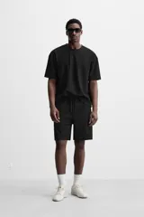 Camiseta negra de corte holgado, con cuello redondo y mangas cortas.