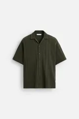 Camisa verde militar de manga corta con cuello bowling, corte relaxed fit y cierre frontal con botones.