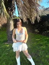 Conjunto de encaje blanco compuesto por un top halter y una minifalda con short incorporado.