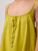 Vestido corto de algodón y lino color negro, con tirantes finos y escote recto con lazo ajustable.