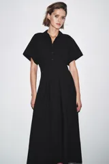 Vestido midi de algodón color negro, con cuello solapa, manga corta y falda evasé. Cierre frontal con botones y lateral con cremallera oculta.