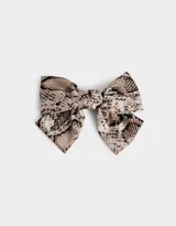 Hebilla francesa con moño grande de tela con estampado de piel de serpiente en tonos beige, marrón y negro.