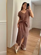 Remera color marrón de hilo de algodón con punto calado, escote en V, manga corta, silueta oversize y tajos laterales.