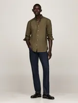 Camisa verde militar de corte regular, con cuello abotonado y mangas largas con puños abotonados. Logo de Tommy Hilfiger bordado en el pecho.