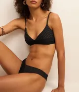 Bombacha de bikini negra con costuras contrastantes y corte de pierna alto.