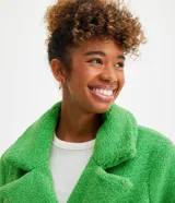 Campera alargada de sherpa verde con cuello solapa, cierre cruzado con botones y bolsillos delanteros.