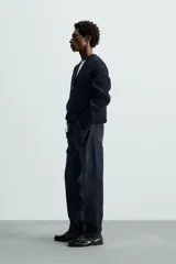 Cárdigan azul marino de punto con cremallera frontal, cuello en pico y manga larga.