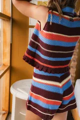 Short tejido a crochet con cintura elastizada y tiro alto, con rayas horizontales en tonos naranja, marrón, blanco y negro.