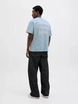Camiseta celeste de manga corta y cuello redondo, con calce holgado y estampado pequeño en el pecho.