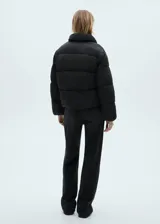 Campera puffer negra con cuello de piel sintética removible, cierre frontal con cremallera y botones a presión, bolsillos laterales con ribete, mangas largas con puños elásticos, diseño crop, acolchado, oversize y forro interior.