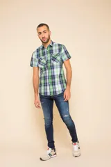 Camisa de manga corta con estampado a cuadros en tonos azul, rojo y blanco. Cierre con botones y tela ligera.