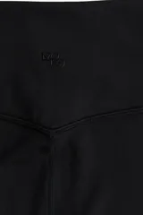 Calzas deportivas negras de tejido funcional DryMove™ que ayuda a absorber el sudor. Diseño con cintura ancha de tiro alto y bolsillo oculto en la parte trasera.