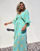 Vestido túnica largo color verde agua con estampado dorado, escote en V y mangas anchas.
