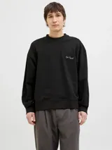 Buzo negro de manga larga con cuello redondo, fit oversize y estampa en la espalda con dibujo de flores en un jarrón.