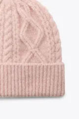 Gorro de lana color rosa con diseño de punto trenzado.