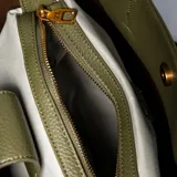 Cartera tipo tote grande color verde, confeccionada en cuero sintético. Tiene doble asa corta, correa larga regulable y desmontable, acceso superior abierto y herrajes plateados.
