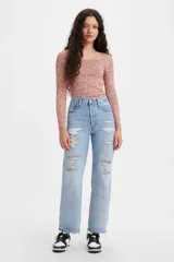 Pantalón de jean celeste claro, de corte recto, tiro alto y largo hasta el tobillo. Presenta roturas grandes en ambas piernas y terminación desflecada.