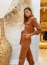 Mono color ladrillo con cuello camisero, manga larga con puños abotonados, bolsillos en el pecho y laterales, y cinturón de lazo en la cintura.