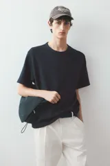 Remera negra de algodón con textura waffle, cuello redondo ribeteado y corte estándar.