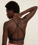 Top deportivo negro confeccionado en microfibra sin estampa, con espalda abierta y breteles finos cruzados.