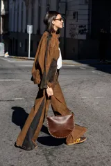 Pantalón de jean marrón con paneles laterales negros, corte amplio y tiro alto.