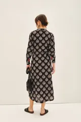 Camisa larga de algodón con estampado de hojas en blanco y negro, cuello en V, botones frontales, lazo en la cintura y tajos laterales.