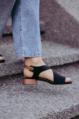 Sandalias de cuero color beige con tiras cruzadas y hebilla lateral. Taco cuadrado color marrón oscuro.