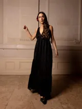 Vestido largo negro con escote en V, breteles finos con lazo y bordados florales a tono. Corte imperio y falda amplia con volados. 